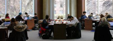 Students studying at tables inside a UUֱ library. 